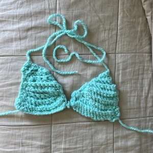 Turkos stickad bikini med snörning - Superfin turkos bikiniöverdel i grovstickat material med snörning både i nacken och runt ryggen. Triangelformade kupor ger en trendig och chill vibe, perfekt för strandhäng eller poolparty. Unik handgjord och riktigt mjuk mot huden.
