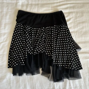 Prickig volangkjol från Lucie Fashion - Jättesöt svart kortkjol med vita prickar från Lucie Fashion Paris. Den stretchar i midjan så den passar flera storlekar. Skriv till mig om du har frågor😽