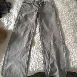 Grå raka jeansbyxor - Säljer ett par grå jeansbyxor med rak passform och klassisk femficksdesign. Jeansen är midwaisy och har en väldigt fin passform! 