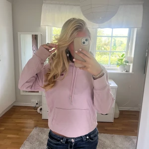 Ljusrosa hoodie från Levi's - Säljer en ljusrosa hoodie från Levi's med klassisk logga på bröstet. Tröjan har huva med snörning. Långärmad och mjuk i bomullsmaterial. Supermysig i höst och vinter!💞