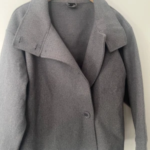 Grå kappa från Gina Tricot, storlek S - Säljer en stilren grå kappa från Gina Tricot i storlek S. använd fåtal gånger 