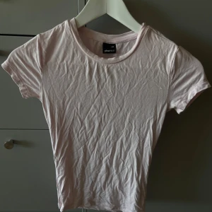 Ljusrosa t-shirt från Gina Tricot - Supersöt ljusrosa t-shirt från Gina Tricot i mjuk bomull. Modellen är klassisk med rund hals och korta ärmar, perfekt för en chill och enkel look. Passformen är normal och tyget är tunt och skönt mot huden. Enkelt att matcha med jeans eller shorts. Tröja är oanvänd då den inte passade men behövs möjligtvis strykas🩷