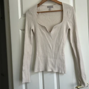 Ribbad beige topp med v-ringning H&M - Har inte använt på 2 år och är helt som ny förutom defekten som man kan se i sista bilden. den är storlek M men passar mer som S 🥰💕💕 perfekt för hösten 