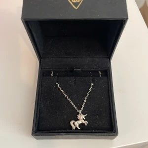 Unicorn-halsband i silver Maria Nilsdotter - Maria Nilsdotter halsband. Unicorn halsband i silver från Maria Nilsdotter. Kvitto och orginal box kommer med. Sparsamt använd. Längd 45