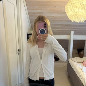 Vit kofta från KappAhl med knappar - Säljer en enkel och fräsch vit kofta från KappAhl i storlek S. Koftan passar till alla outfits nu på sen sommarn samt höst