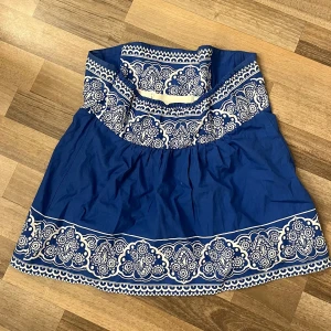 Tube top - Snygg tube top med vitt blommigt mönster längs överdelen och nederkanten. Klänningen har en söt och somrig vibe med voluminös kjol och är perfekt för varma dagar. Tillverkad i bomull för en skön och luftig känsla. Passar jättefint till jeans 