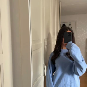 Ljusblå sweatshirt med rund hals - En enkel och snygg ljusblå sweatshirt med rundad hals och ribbade muddar vid ärmslut och nederkant. Tröjan har en loose passform och är tillverkad i mjuk bomull, perfekt för chill dagar. Passar dig som gillar stilrena och bekväma plagg. Nästan aldrig använd och enligt mig fortfarande lika mjuk på insidan som när den köptes💕