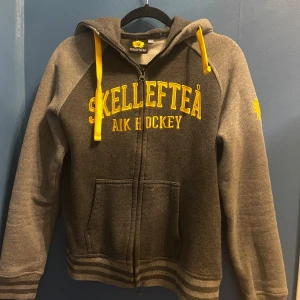 Skellefteå AIK huvtröja - Skellefteå AIK huvtröja från officiella shoppen. Storlek 158/164