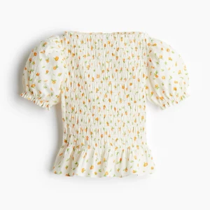 Vit topp med apelsiner - Säljer denna topp från hm i storlek S, toppen är vit med apelsiner på och puffiga ärmar, bra skick använd nån enstaka gång