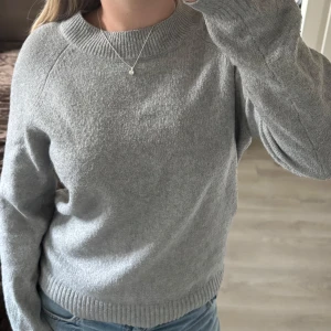 Grå stickad tröja från Vero Moda - Säljer denna stickad långa tröjan från Vero Moda. Den är gråstickad och funkar perfekt nu till hösten. Säljer då den inte längre kommer till användning💕