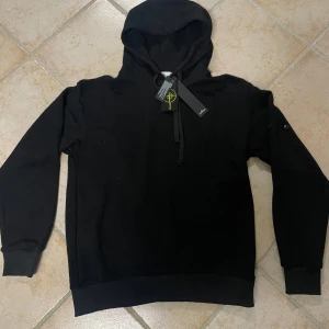 Svart hoodie från Stone Island - Svart hoodie från Stone Island med klassisk huva och snörning. Basic men snygg hoodie som passar till allt. Skriv för minsta fundering 