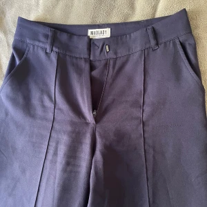 Mörkblå kostymbyxor från Madlady - Snygga mörkblå kostymbyxor från Madlady med klassisk rak passform och pressveck framtill.  Stl 34/34 nästintill oanvända 