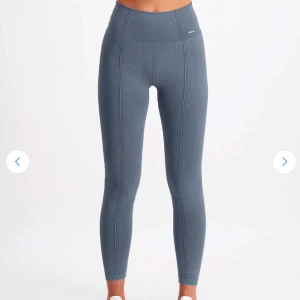 Aimn tights - Säljer träningstights från Aim'n med hög midja och tight passform. De är gjorda i mjukt och stretchigt syntetmaterial som sitter skönt mot kroppen. Perfekta för träning eller chill hemma. Snygga sömmar längs benen ger en sportig vibe.