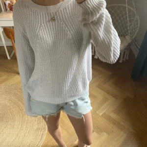 Vit stickad tröja - Säljer en mysig vit stickad tröja med rund hals och långa ärmar. Perfekt för kyligare dagar och lätt att matcha med olika outfits. Tröjan har en avslappnad passform och ribbade kanter vid ärmslut och nederkant.