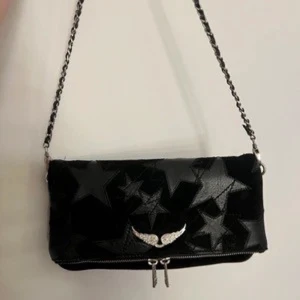 Svart axelväska från Zadig & Voltaire - Säljer min fina svarta axelväska från Zadig & Voltaire med stjärnmönster och silverdetaljer. Använd bara några enstaka gånger så inga defekter.  Dustbagen tillkommer💞🫶 pris kan diskuteras 
