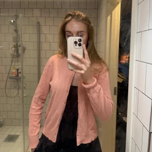 Rosa kofta  - Säljer en söt rosa kofta från H&M. Den har långa ärmar och knappar framtill. Perfekt för att lägga till en färgklick i din garderob!