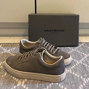 Grå sneakers från Vagabond - Snygga grå sneakers från Vagabond i mocka med vit sula. Skorna är ändast använda ett fåtal gånger och är i skicket 9/10