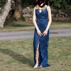 Balklänning med spetsdetaljer 💙 - Marinblå balklänning med en slits framtill och spetsdetaljer. Endast använd en gång, så den är i mycket bra skick. Klänningen är insydd lite i midjan och axelbanden är även uppsydda lite🦋🦋