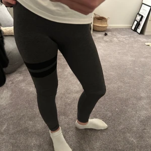 Tränings tajts - Snygga grå leggings med två svarta ränder runt låret. Stl xs-s från stronger