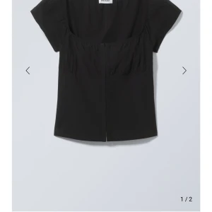 Svart kortärmad topp från Weekday - Snygg svart topp från Weekday med korta ärmar och en enkel design. Perfekt för en stilren look. Toppen har en rak passform och är tillverkad i ett mjukt material. Ny med prislapp kvar. 