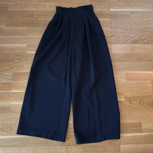 Svarta vida kostymbyxor - Svarta vida kostymbyxor. Ger illusionen av en hour glas form