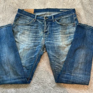 Dondup jeans - Snygga blå jeans från dondup med en klassisk femficksdesign och lätt slitna detaljer. Perfekta för en avslappnad stil. De har en knappgylf och är tillverkade i ett robust denimtyg.