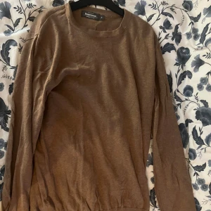 Brun tröja från Dressmann - Säljer en brun tröja från Dressmann i Supima bomull. Tröjan har en enkel design med rund hals och långa ärmar. Perfekt för en stilren och bekväm look.