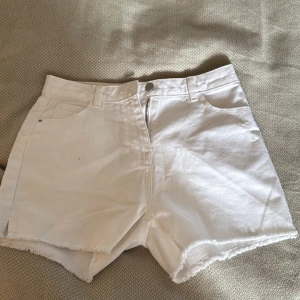 Vita shorts från Next - Säljer ett par vita shorts från Next. De är högmidjade med fransiga kanter och har en klassisk femficksdesign. Perfekta för sommardagar! i nytt skick 