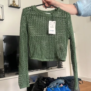 Grön stickad tröja från Zara - Säljer en snygg grön stickad tröja från Zara. Tröjan är croppad 