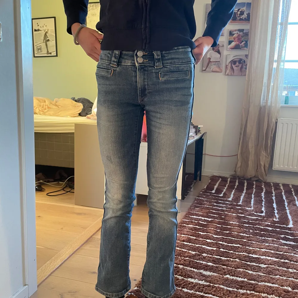 Snygga blå jeans med bootcut och låg midja. De har en klassisk femficksdesign. Perfekta för en avslappnad stil.I strl.152. Farkut & Housut.