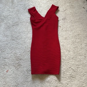 Röd axelbandslös klänning - Snygg röd klänning med axelbandslös design och ribbad textur. 