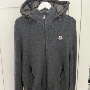 Moncler Tricot Cardigan - Moncler Tricot Cardigan, inga tecken på användning. Äktehetsveriferad hos Moncler, köpt på Moncler butiken för 10499. Väldigt stil ren med en fin färg, väldigt eftertraktad Model just nu på marknaden. Storlek L men passar mer för dom som har M monclers storlekar är små i storleken.