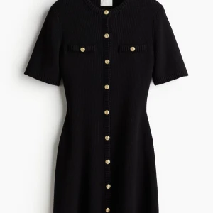 Svart stickad klänning med guldknappar - Endast testad!!⭐️⭐️                                                      Ni får gärna komma med prisförslag!⭐️                               Snygg svart klänning från H&M med korta ärmar och dekorativa guldknappar framtill. Klänningen har en ribbad struktur och två små fickor på bröstet. Perfekt för en stilren look
