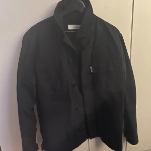 Mörkblå overshirt  - Säljer en riktigt snygg navy blue overshirt, med knappar framtill och en bröstficka. Perfekt för lager-på-lager-stil. Den har en stilren design med långa ärmar och en klassisk krage. Använd ett fåtal gånger men är helt som nya inga defekter förekommer. Märket heter Whyred och den är köpt på Brothers, nypris 1500 mitt pris 400!