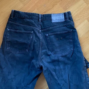 Mörkblå byxor från True Relic - Snygga svarta byxor från True Relic, tillverkade i Italien. Byxorna har en klassisk design med fem fickor och en dragkedja framtill. Perfekta för en stilren look.