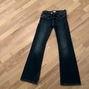 Mörkblå bootcut jeans - Snygga mörkblå bootcut jeans med klassisk femficksdesign och knappgylf. De är låg midjade och ganska nya och är i stl 158 