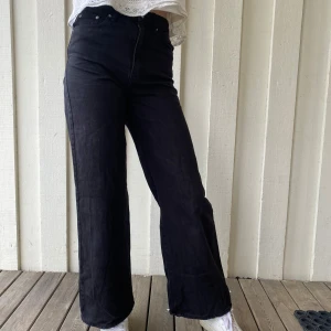 Svarta jeans från Gina Tricot - Snygga svarta jeans från Gina Tricot med en rak passform. De är tillverkade av mer hållbar bomull och har en klassisk design med dragkedja och knapp framtill. Perfekta för en stilren look.