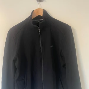 Svart tröja från Hugo boss - Fullzip från Hugo boss, riktig bra skick och ritkigt snygg. Säljer den då de inte är min stil längre. Storlek M