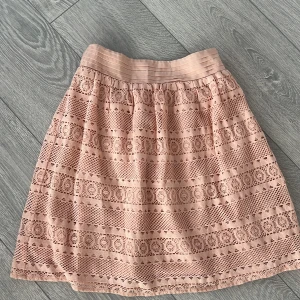 Rosa spetskjol från Dorothy Perkins - Söt rosa kjol i spets från Dorothy Perkins. Kjolen har ett elastiskt midjeband och ett vackert spetsmönster som ger en romantisk känsla. Perfekt för en somrig look! Passar även större stl 