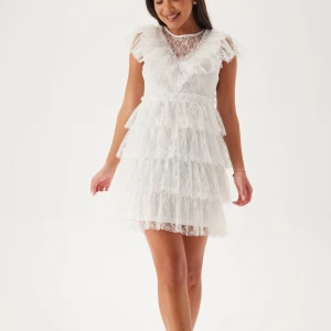 Vit spetsklänning med volanger - Säljer denna klänning från bubbleroom som är helt slutsåld i denna storlek. Perfekt nu till studenten. Oanvänd och prislappen kvar💕