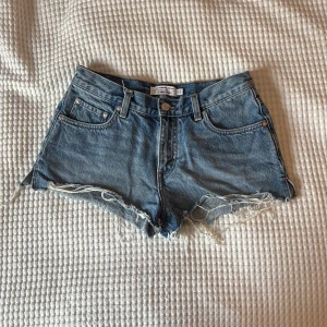 Lågmidjade jeansshorts  - Snygga lågmidjade jeansshorts med fransiga kanter. I nyskick, ändrat provade och tvättade. Köpta för 800kr säljs för 400kr, helt slutsålda.