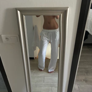 Vita linnebyxor med dragsko - Säljer ett par vita linnebyxor med avslappnad passform och dragsko i midjan. Byxorna har raka ben och fickor på sidorna samt baktill. Perfekta för varma dagar och enkel stil. Jag är 172, har storlek S/M men XS sitter såhär på mig❤️