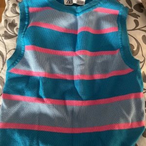 Randig stickad linne från Zara - Säljer en färgglad stickad linne från  Zara med breda ränder i turkos, ljusblått och rosa. 🥰