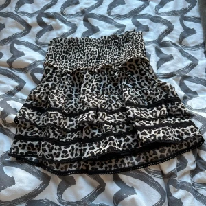 Leopardmönstrad volang-tubtopp - Säljer en snygg tubtopp med leopardmönster och volanger. Toppen har smock upptill för bra passform och flera lager volanger som ger en cool look. Perfekt för dig som vill sticka ut lite extra!