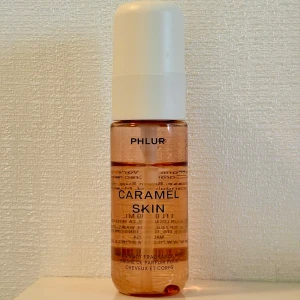 Caramel Skin Body Mist från Phlur - En söt och gourmand body mist från Phlur med doft av karamell, bergamott, varm mjölk, vanilj, brunt socker, sandelträ och mysk. Perfekt för dig som älskar varma, söta dofter. 30 ml, kvarvarande mängd syns tydligt på bilden. En fantastisk doft som inte går att få tag på då den inte fraktas till Sverige. 