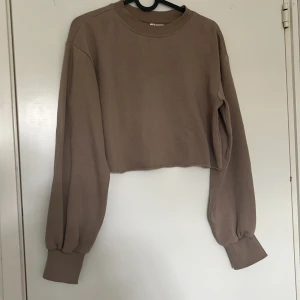 Beige croppad sweatshirt från Divided - Säljer en brun croppad sweatshirt från H&M, använd men inga direkt skavanker. 💕