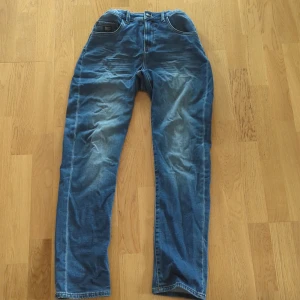 Blå jeansbyxor från LAB Industries - Säljer ett par blå jeansbyxor från LAB Industries, modell Eddy Relaxed Fit. Byxorna har klassisk femficksdesign, normal passform. Perfekta för dig som gillar en avslappnad stil. Inga hål eller fläckar.