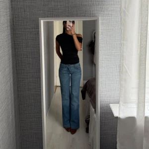 Blå bootcut jeans från Levis - Säljer ett par klassiska blå bootcut jeans från Levis med hög midja. Jeansen har fem fickor, dragkedja och knapp framtill samt Levis-lapp bak i midjan. Perfekta för dig som gillar en retroinspirerad look. Midja ca 74 innerben ca 83