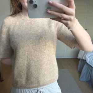 Beige stickad tröja STOCKH LM - Beige stickad kortärmad tröja från STOCKH LM. Är tillverkad i en lyxig blandning av alpacka vilket gör att den är lite fluffigare. I storlek S och är bara använd 1 gång🩷