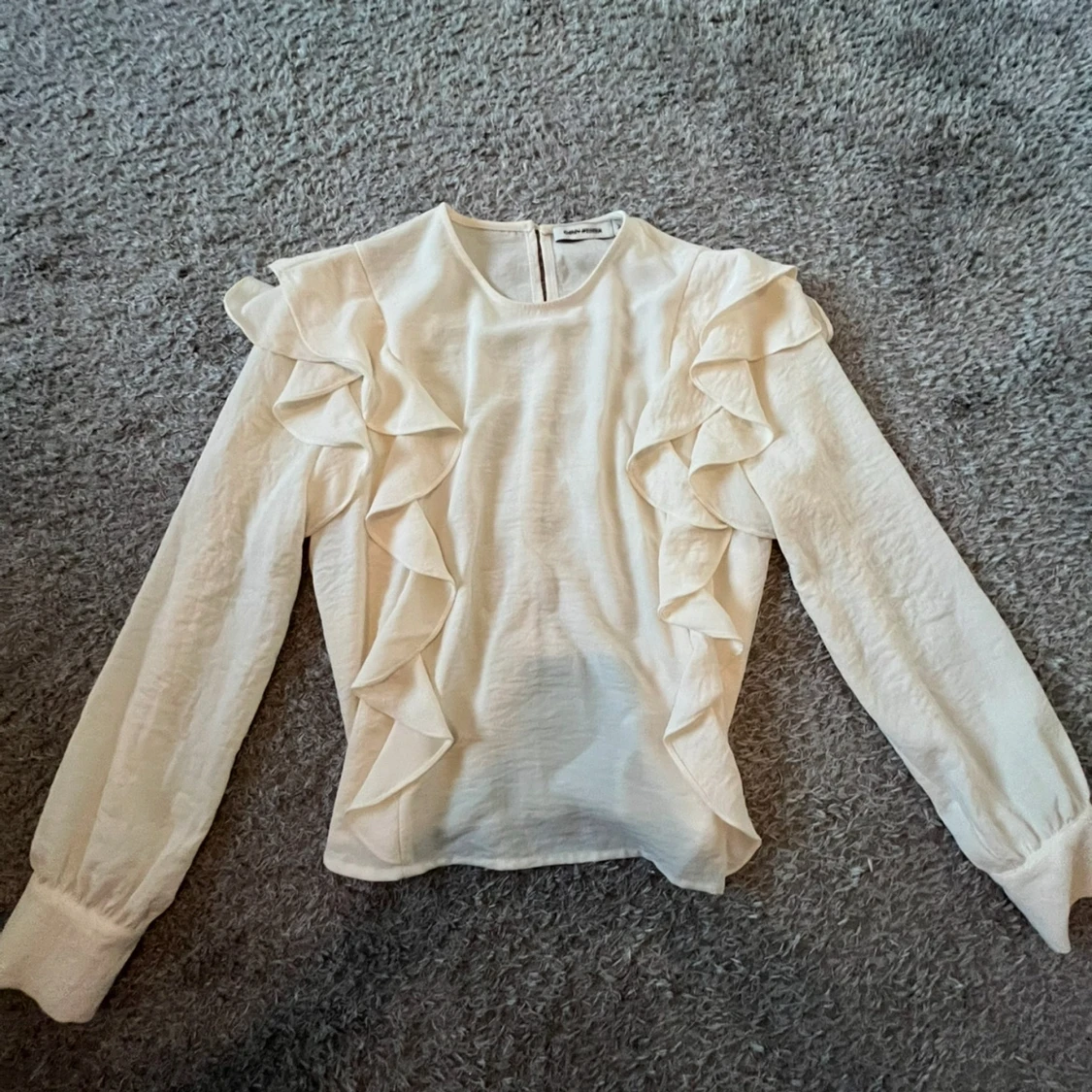 Vit blus med volangdetaljer